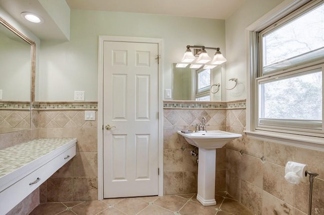 bathroom with tile patterned floors, a wainscoted wall, and tile walls