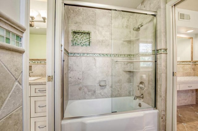 bathroom featuring tile patterned floors, visible vents, shower / bath combination with glass door, and vanity