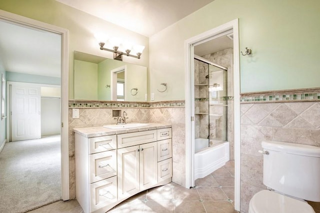 full bath featuring tile patterned floors, shower / washtub combination, toilet, and tile walls