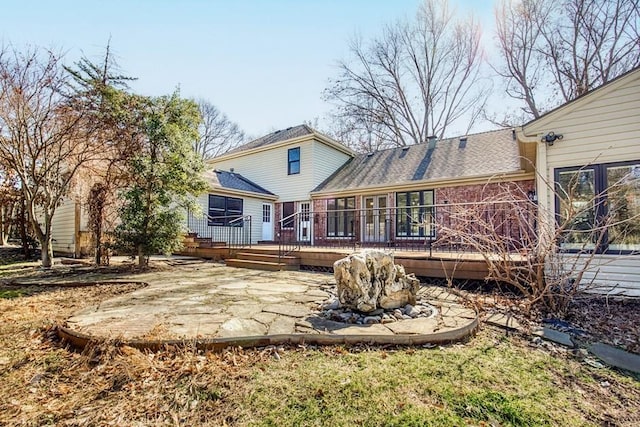 rear view of property with roof with shingles and a deck