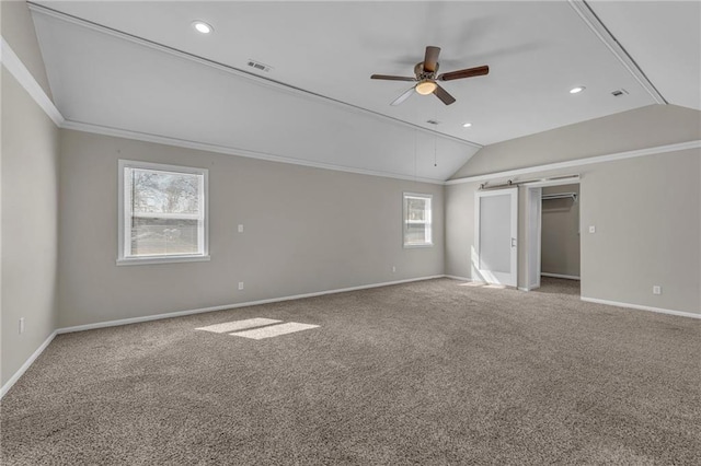 unfurnished bedroom featuring baseboards, visible vents, vaulted ceiling, crown molding, and carpet flooring