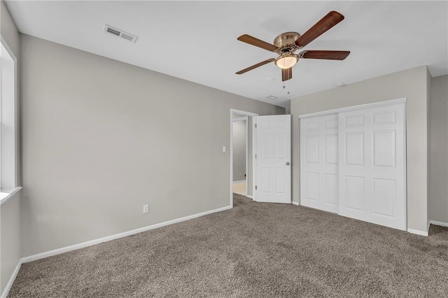 unfurnished bedroom featuring carpet flooring, baseboards, visible vents, and a closet