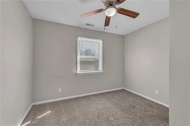 carpeted spare room featuring visible vents, baseboards, and a ceiling fan