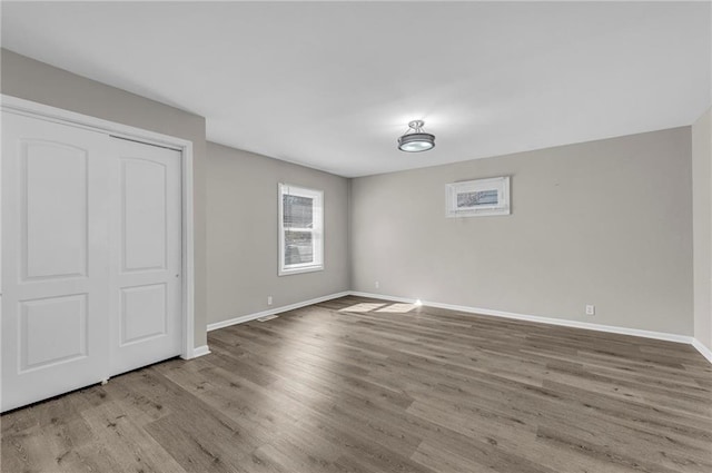 unfurnished bedroom featuring a closet, baseboards, and wood finished floors