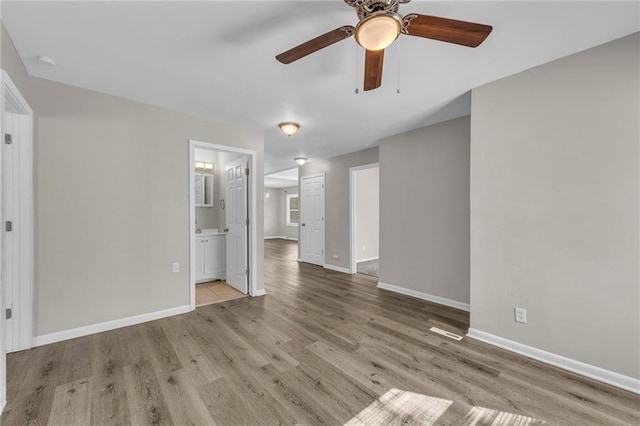 unfurnished living room featuring visible vents, baseboards, a ceiling fan, and wood finished floors