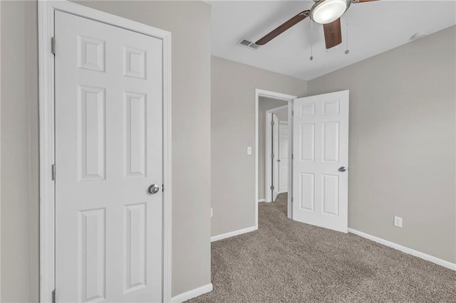 unfurnished bedroom with a ceiling fan, carpet flooring, baseboards, and visible vents