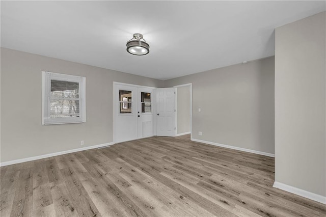 spare room featuring baseboards and wood finished floors