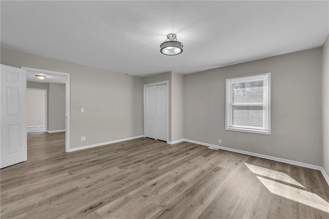 unfurnished room featuring baseboards and wood finished floors