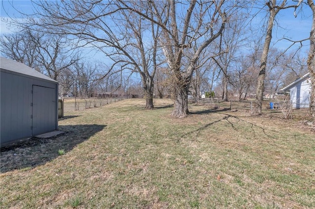 view of yard with an outbuilding, a storage shed, and fence