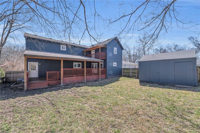 rear view of property featuring fence, a yard, a storage shed, an outdoor structure, and a wooden deck