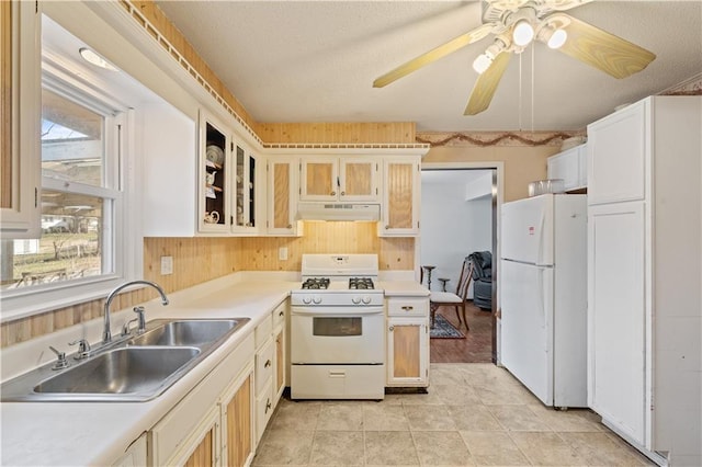 kitchen featuring under cabinet range hood, light countertops, white appliances, a ceiling fan, and a sink