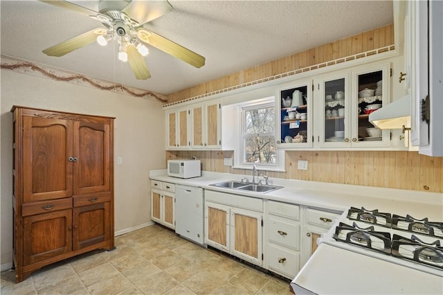 kitchen featuring extractor fan, light countertops, white appliances, a textured ceiling, and a sink