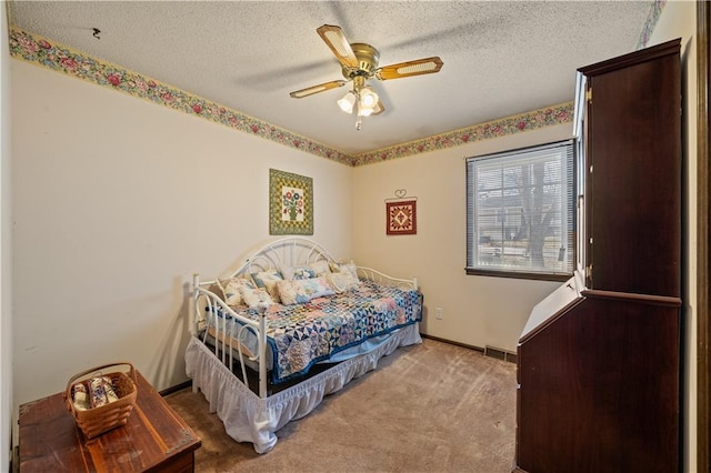 carpeted bedroom featuring visible vents, baseboards, a textured ceiling, and a ceiling fan