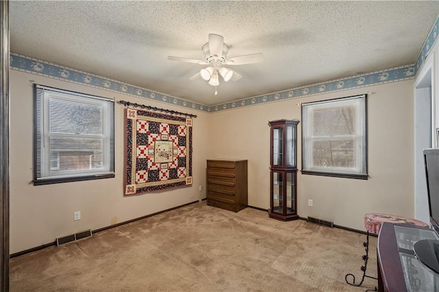 interior space with visible vents, baseboards, carpet flooring, and a ceiling fan