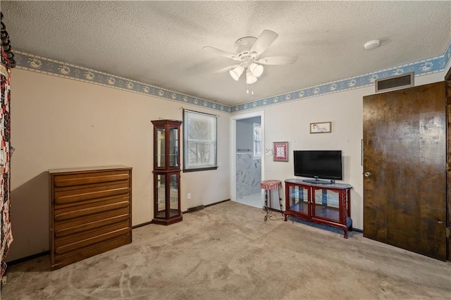 interior space featuring visible vents, baseboards, carpet floors, a textured ceiling, and a ceiling fan