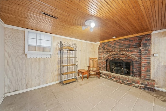 unfurnished room featuring visible vents, a brick fireplace, wooden walls, and wood ceiling