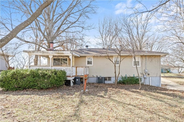 back of property with a chimney, central air condition unit, and a pergola