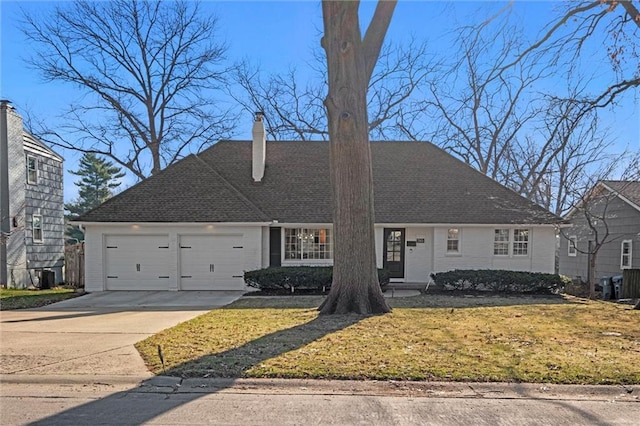 view of front of house featuring central AC, driveway, a front yard, and a garage