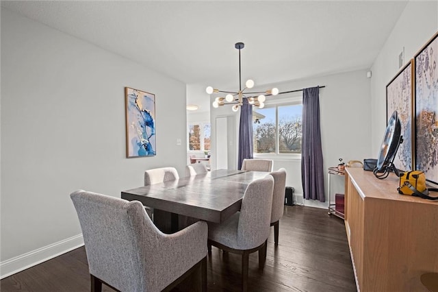 dining space with a chandelier, baseboards, and dark wood finished floors