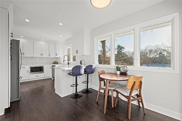 dining room featuring recessed lighting, baseboards, and dark wood-style floors