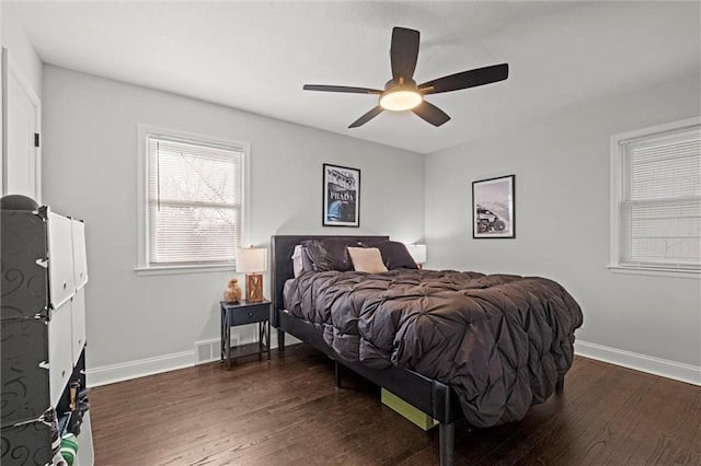 bedroom featuring a ceiling fan, visible vents, wood finished floors, and baseboards