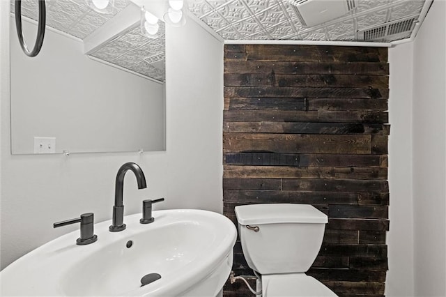 bathroom featuring toilet, visible vents, an ornate ceiling, and a sink