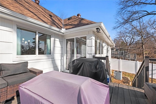 wooden deck featuring central air condition unit, fence, and grilling area