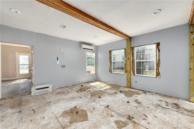 spare room featuring beamed ceiling, an AC wall unit, and a wall mounted AC