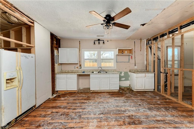 kitchen with a ceiling fan, a sink, dark wood-style floors, white fridge with ice dispenser, and white cabinets