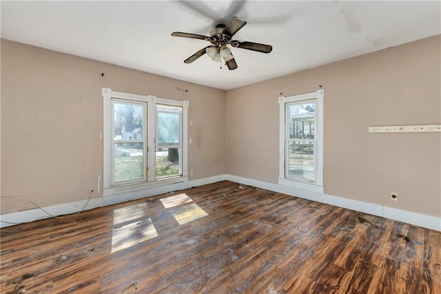 unfurnished room featuring a ceiling fan, wood finished floors, and baseboards