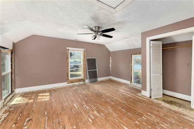 unfurnished bedroom featuring baseboards, lofted ceiling, and hardwood / wood-style flooring