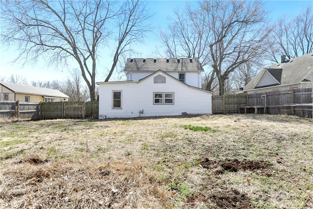 back of property with a yard and a fenced backyard