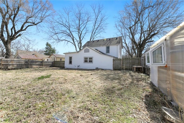 back of house with a yard, an outbuilding, and a fenced backyard