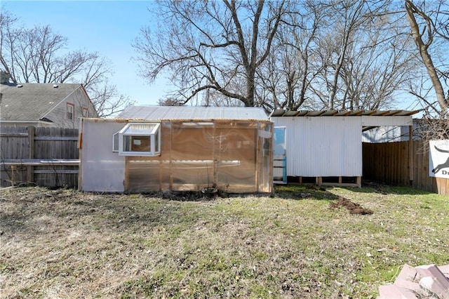 exterior space with an outdoor structure, a storage unit, and fence