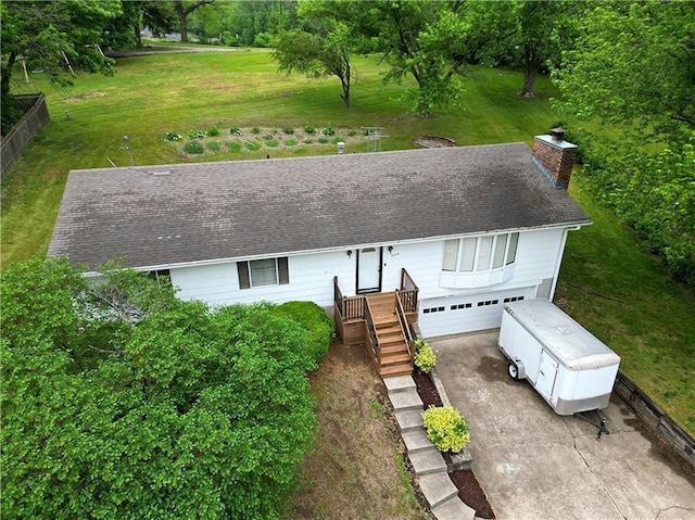 2213 Millwood Dr, Atchison, KS 66002 - view of front facade with a garage, a front yard, driveway, a chimney, and a shingled roof