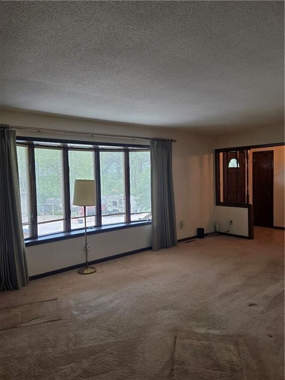 2213 Millwood Dr, Atchison, KS 66002 - unfurnished room with light colored carpet, healthy amount of natural light, and a textured ceiling