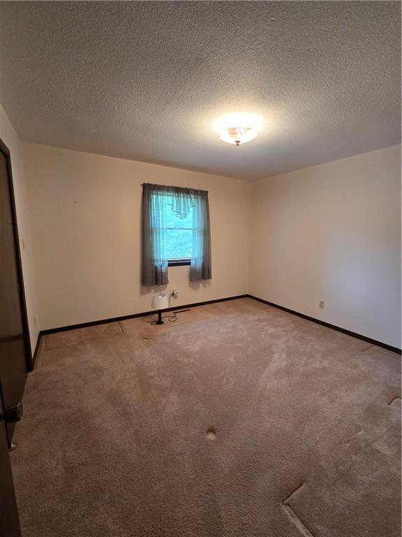 2213 Millwood Dr, Atchison, KS 66002 - spare room featuring a textured ceiling and light carpet