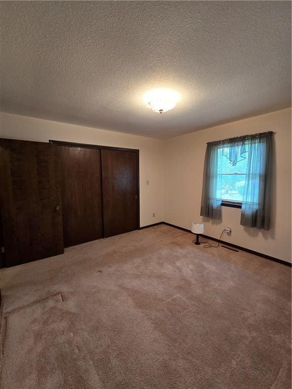 2213 Millwood Dr, Atchison, KS 66002 - unfurnished bedroom with light carpet, a textured ceiling, and a closet