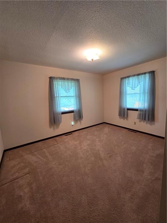 2213 Millwood Dr, Atchison, KS 66002 - empty room featuring healthy amount of natural light, carpet floors, and a textured ceiling