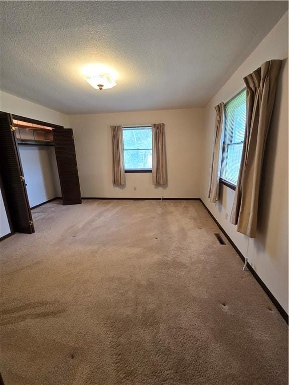 2213 Millwood Dr, Atchison, KS 66002 - unfurnished bedroom featuring a textured ceiling and light carpet