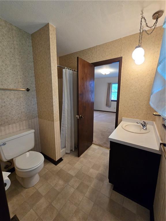 2213 Millwood Dr, Atchison, KS 66002 - bathroom with vanity, a shower with curtain, wallpapered walls, and tile patterned floors