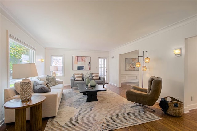 living room featuring plenty of natural light, wood finished floors, baseboards, and ornamental molding