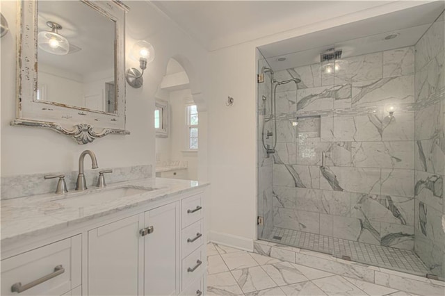 full bath featuring baseboards, vanity, marble finish floor, and a shower stall