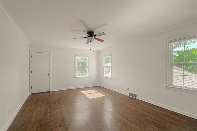 unfurnished room with dark wood finished floors, visible vents, baseboards, and ceiling fan