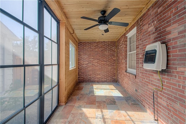 unfurnished sunroom with heating unit, wooden ceiling, and a ceiling fan