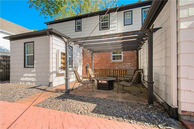 view of patio / terrace with fence, a pergola, and an outdoor fire pit