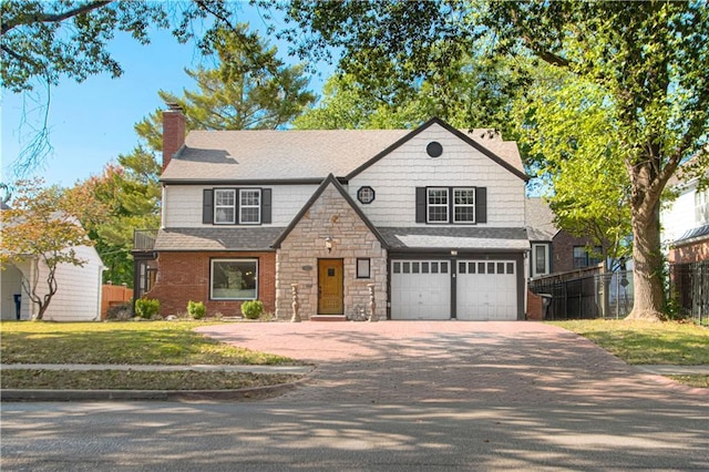 view of front of home featuring fence, a chimney, driveway, stone siding, and an attached garage