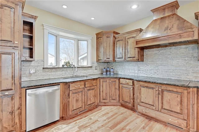 kitchen featuring black electric stovetop, dishwasher, dark stone countertops, custom exhaust hood, and a sink