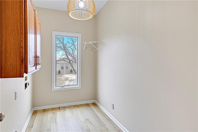 washroom with visible vents, cabinet space, light wood-type flooring, and baseboards