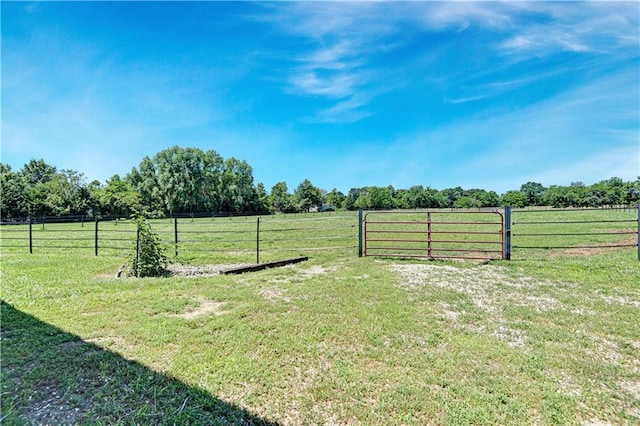 view of yard featuring a gate, a rural view, and fence